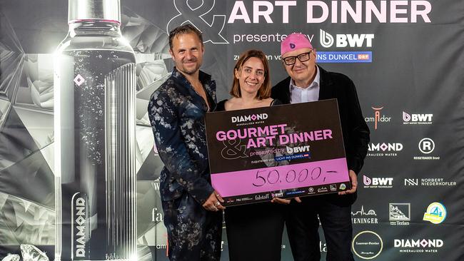 Philipp Hochmaier, Lisa Zuckerstätter und Andreas Weissenbacher halten einen Scheck über 50.000 Euro in die Kamera.