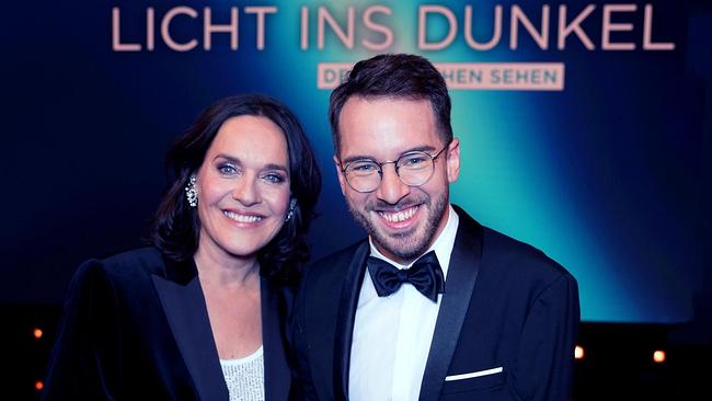 Eva Pölzl und Andreas Onea vor einem "LICHT INS DUNKEL Den Menschen sehen" Schriftzug