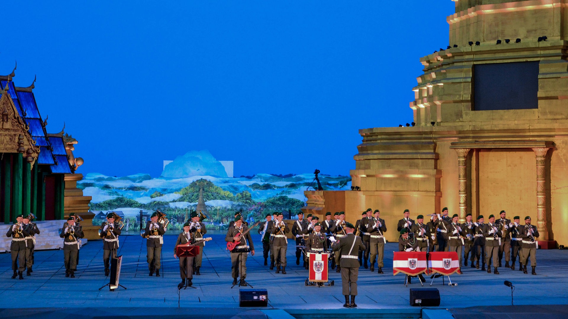 Die selben Musiker*innen wie auf den vorangehenden Bildern. Im Hintergrund sieht man bereits das Bühnenbild für "Der König und Ich", das demnächst auf der Seebühne gespielt wird - asiatisch angehauchte Häuser und ein Tempel.