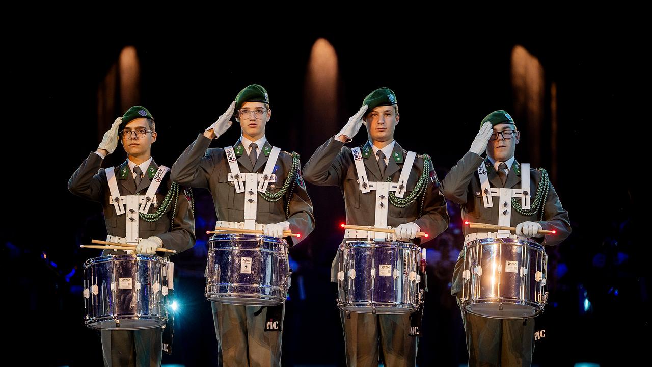 Vier Trommler in Bundesheer-Uniform salutieren.