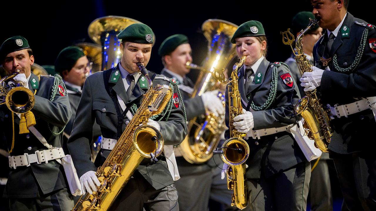 Eine Gruppe Blasmusikerinnen und -musiker in Bundesheer-Uniform beim Musizieren.