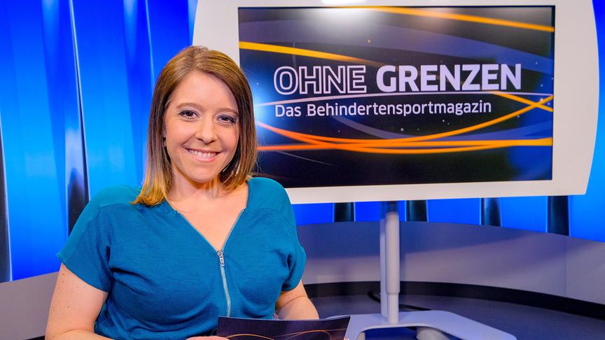 Miriam Lapus präsentiert seit 2018 "Ohne Grenzen - das Behindertensportmagazin" in ORF Sport+. Am Foto ist die Moderatorin in einem blauen Oberteil vor einem blauen Hintergrund und einem Bildschirm zu sehen.